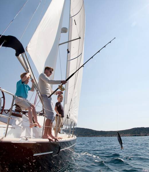 Father and sons fishing on yacht