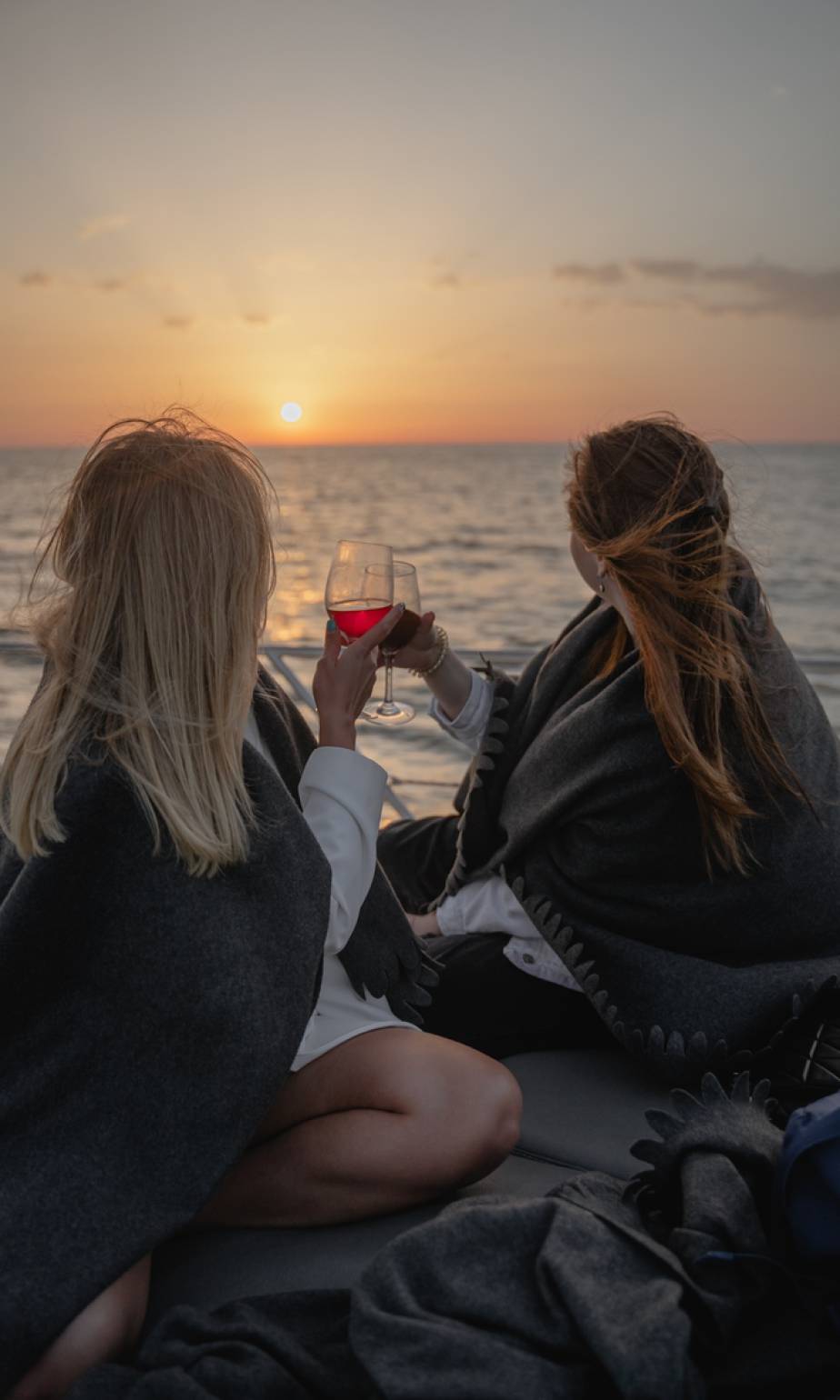 girls-on-a-yacht-with-a-glass-of-wine-during-sunse-2023-11-27-04-56-17-utc